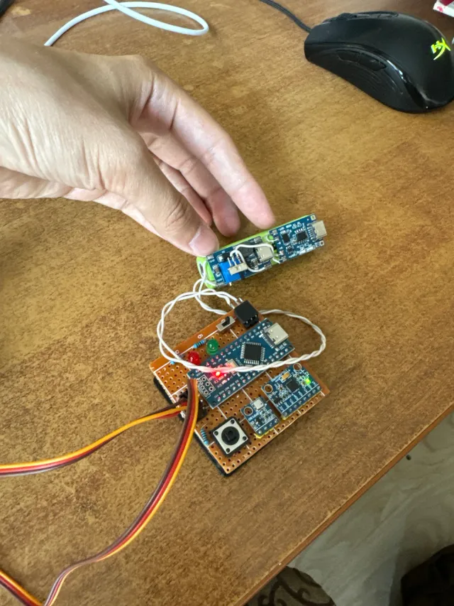 The Arduino avionics powered on the bench, LEDs lit, a battery attached and servo leads trailing