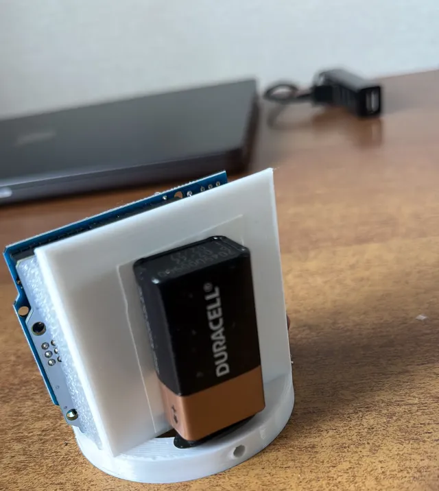 A white 3D-printed sled holding an Arduino board and a 9 V battery