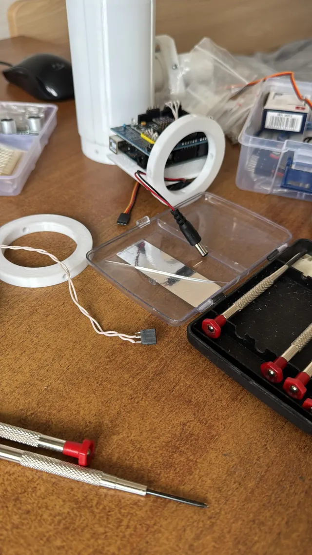 The bench: the white airframe tube, the avionics bay, printed rings, precision screwdrivers and a tool case