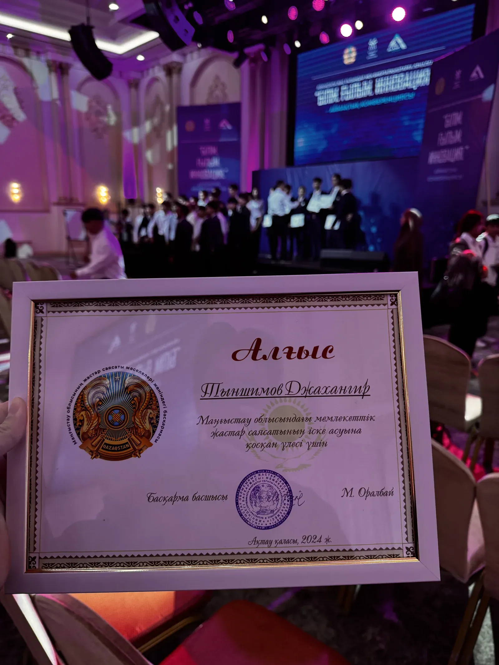 A framed certificate of thanks («Алғыс») made out to Jakhangir Tynshimov for contributing to youth policy in the Mangystau region, 2024