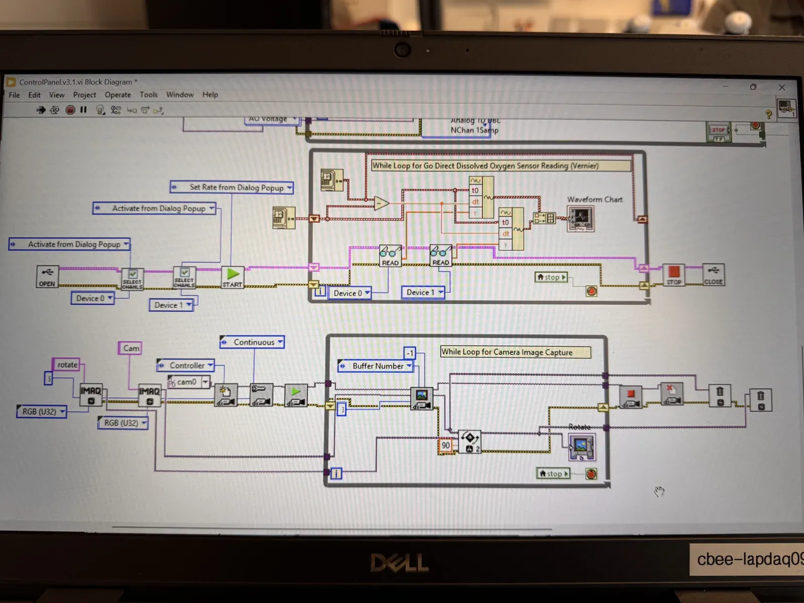 The LabVIEW block diagram on a laptop screen, including the NI-IMAQdx camera image capture loop