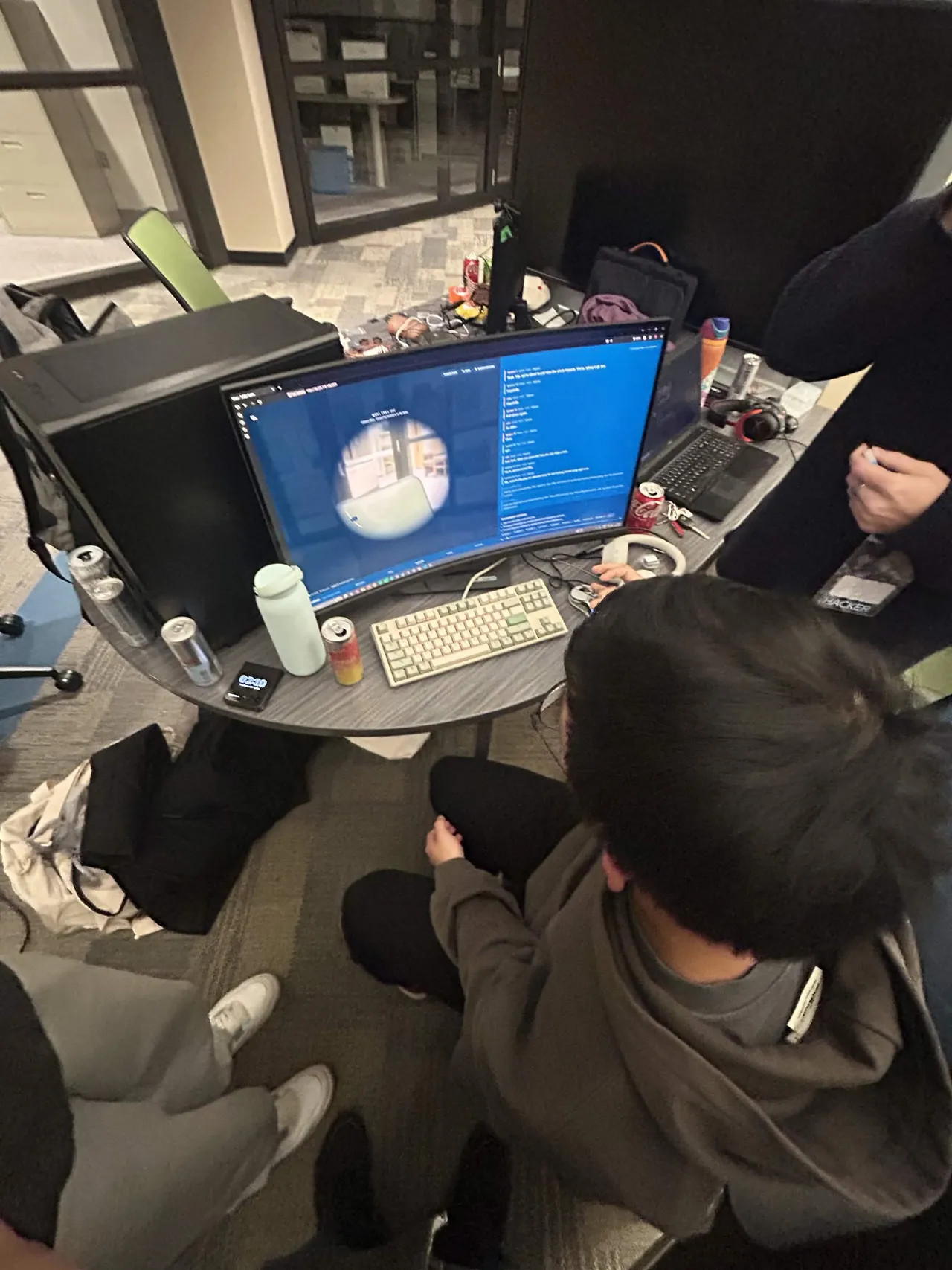 A teammate at a curved monitor showing the judge app: the tunnel-vision circle on the left and the transcript on the right