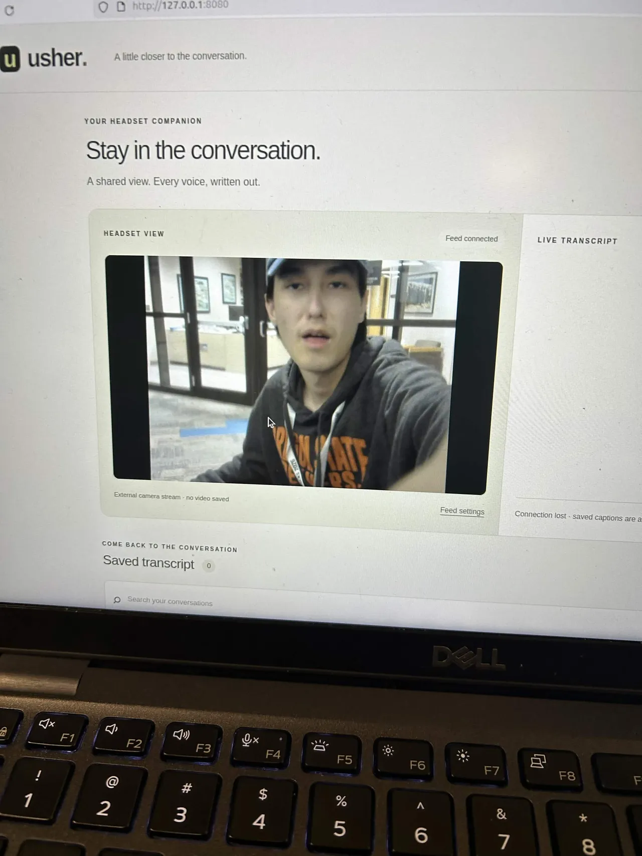 A laptop showing the first version of the web app, 'Stay in the conversation', with Jakhangir in the camera feed